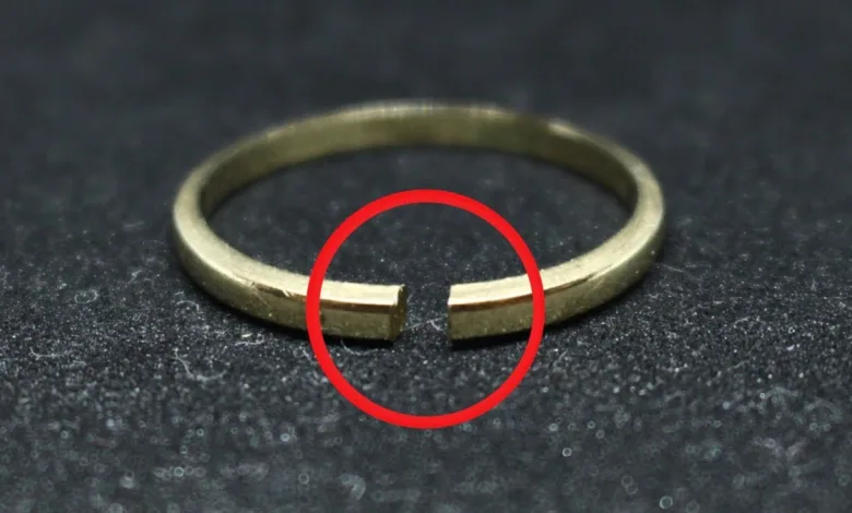 یک حلقه طلای ساده که از روبرو شکسته شده است و یک دایره قرمز دور ناحیه شکستگی وجود دارد. طلا روی یک زمینه سیاه رنگ است