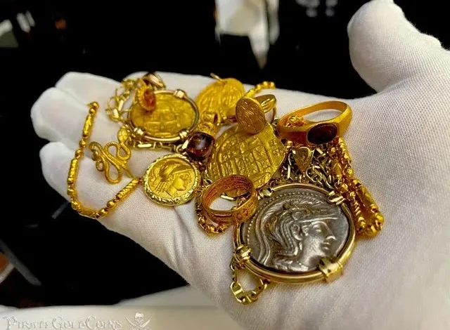 بخشی از انواع مصنوعات طلا در دست یک مرد طلافروش دستکش به دست