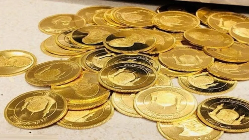 تعداد زیادی سکه طلا که روی یک سطح سفید قرار دارند