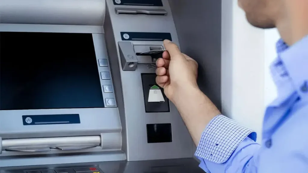 مردی در حال قرار دادن کارت در دستگاه ATM