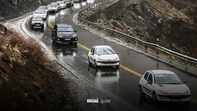 جاده بارانی و تعدادی ماشین که در حال عبور هستند.